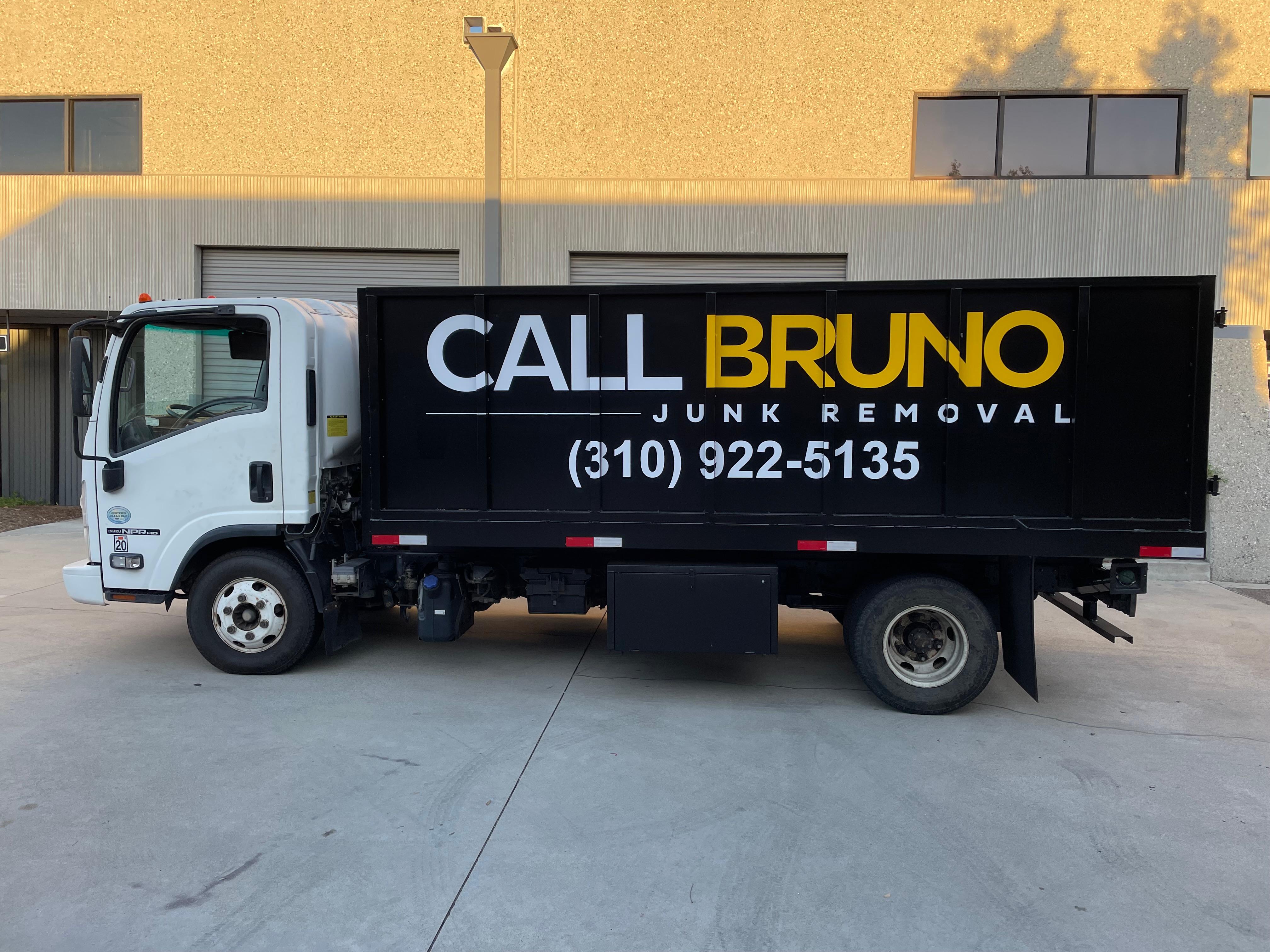 Call Bruno yellow roll-off dumpster being lowered onto a residential California driveway